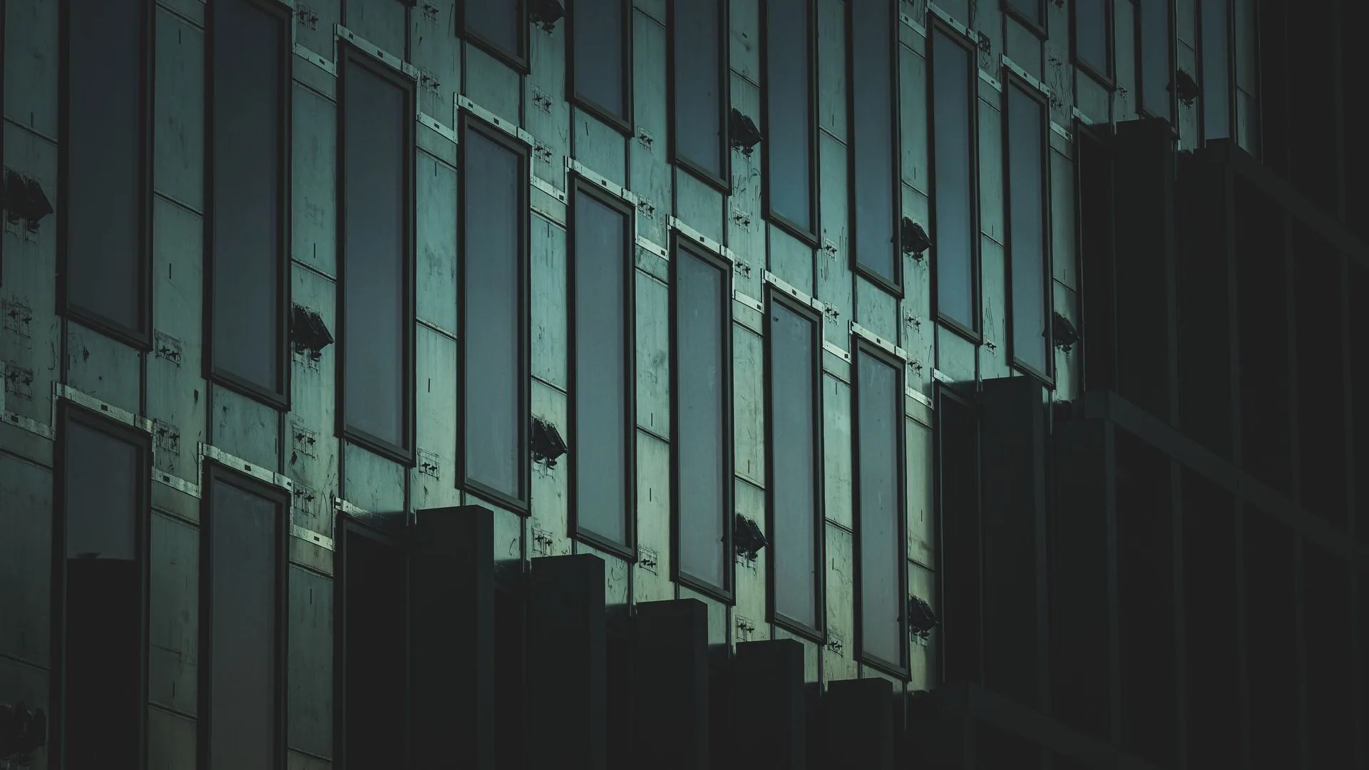 Dark glass and metal curtain wall facade at dusk